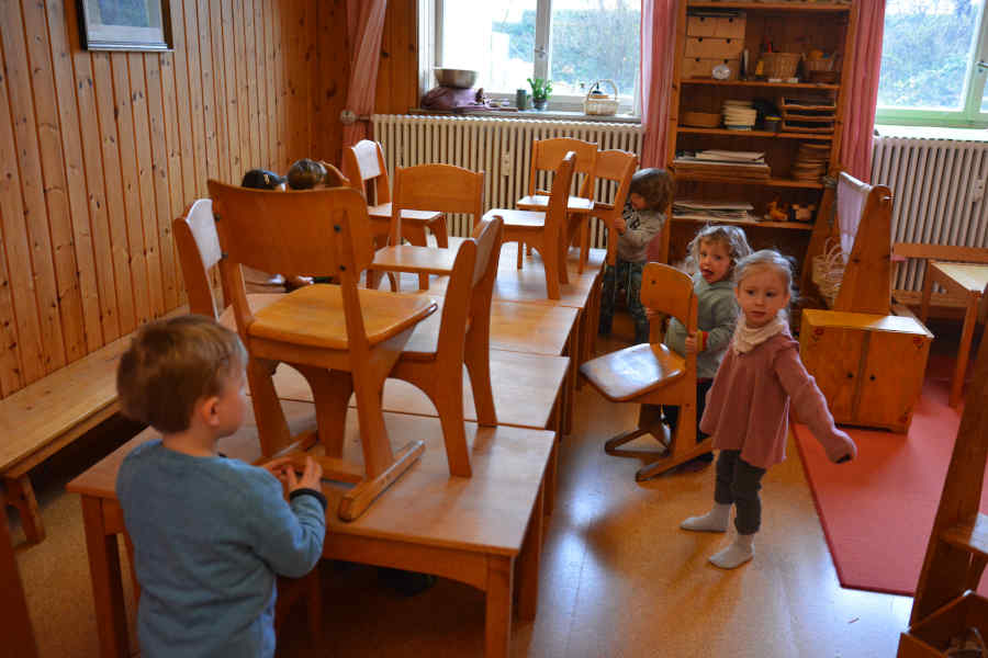 Kinder räumen stühle auf in der spielgruppe rumpelstilzchen